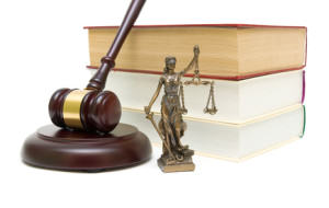 statue of justice, gavel and stack of books isolated on white background close-up. horizontal photo.