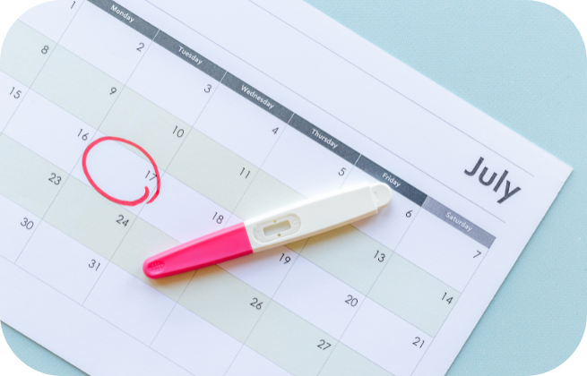 Kalendarz z zaznaczonym terminem i test ciążowy – planowanie badań przed ciążą