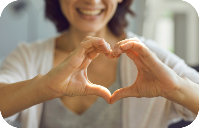 Kobieta pokazująca dłonie w kształcie serca – dbanie o zdrowie przed ciążą