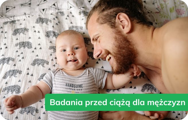 Tata bawi się z niemowlęciem na łóżku – badania przed ciążą dla mężczyzn.