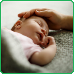 Zdjęcie śpiącego noworodka z dłonią rodzica na głowie – grafika ilustrująca podstawowy panel badania genetycznego GeneScreen® Basic dla par planujących ciążę.